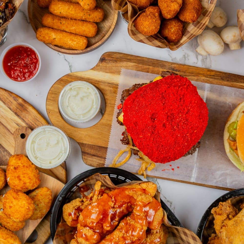 A catering spread of Rodeo Burgers and Chicken burgers, wings, and sides
